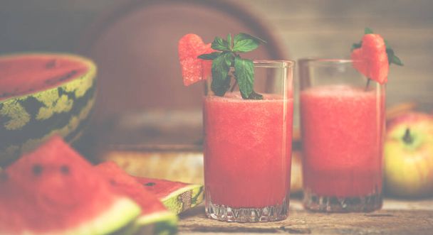 Watermelon on a rustic wooden background. Slices of juicy ripe red watermelon. Fresh juice. Cocktails and soft drinks. Refreshing summer drink. - Foto, Imagen