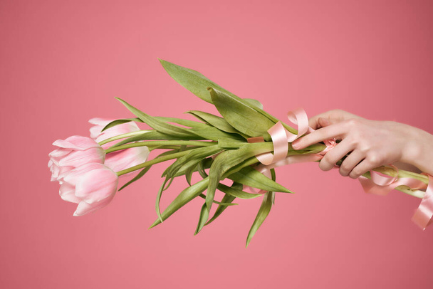 un ramo de flores en la mano y un regalo romance verano rosa fondo - Foto, Imagen