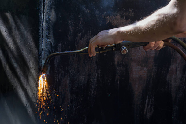 Worker cuts and brews black metal close-up shot - Fotografie, Obrázek