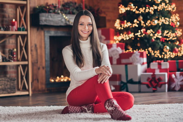 Photo of pretty adorable young woman dressed knitted sweater sitting floor smiling indoors room home house - Foto, afbeelding