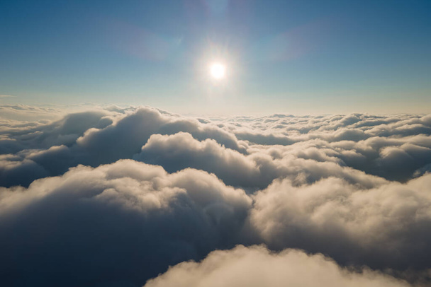 Luftaufnahme aus dem Flugzeugfenster in großer Höhe von dichten, geschwollenen Kumuluswolken, die sich vor dem Regensturm am Abend bilden. - Foto, Bild