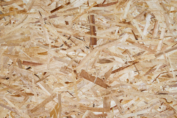 Πάτημα ξύλινο φόντο πάνελ ροκανίδια, υφή του προσανατολισμένου πίνακα σκέλος, OSB. - Φωτογραφία, εικόνα