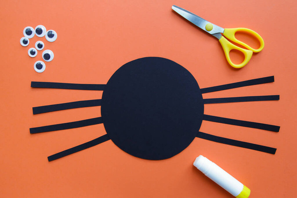 Lapsi luo mustan hämähäkin. Halloween koristelu. Lasten taideprojekti. DIY käsite. Vaiheittain. Vaihe 4 - Valokuva, kuva