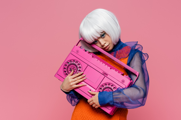 Όμορφη Ασιάτισσα με άσπρη περούκα που κρατάει το κουτί απομονωμένο σε ροζ χρώμα.  - Φωτογραφία, εικόνα