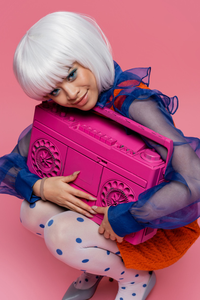 Happy asian model in white wig holding boombox on pink background - Photo, Image