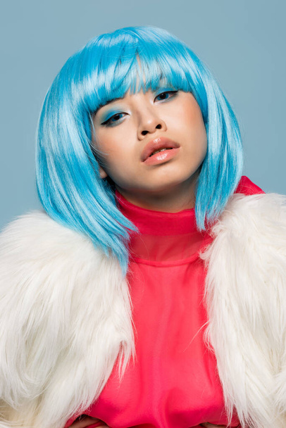 Portrait of asian woman in wig looking at camera isolated on blue  - Photo, Image