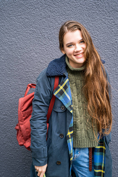 Young smiling brunette woman in casual autumn stylish clothes and red backpack - Foto, Imagen