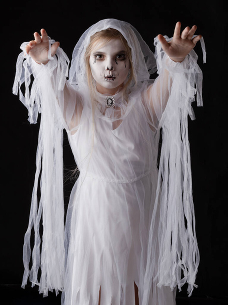 Little girl in Halloween ghost costume walking on you, studio isolated on black background - Foto, Bild