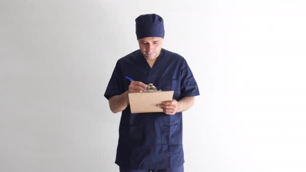 Férfi ápoló, orvos vagy állatorvos kék egyenruhában egy ablakban a kórházban, kezében egy mappát egy jelentést, és mosolyogva. Orvosi, kórházi és egészségügyi koncepció. - Felvétel, videó