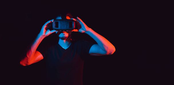 Ένας νεαρός που χρησιμοποιεί υψηλής τεχνολογίας γυαλιά εικονικής πραγματικότητας. με χώρο για κείμενο - Φωτογραφία, εικόνα