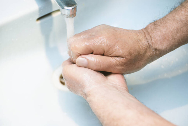 man washes  hands with soap in the bathroom.The best protection against corona virus infection.Corona Virus pandemic protection by cleaning hands frequently. - Fotoğraf, Görsel