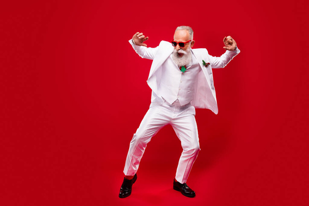 Full size photo of funky elder grey hair man dance wear eyewear white suit isolated on red color background - Photo, Image