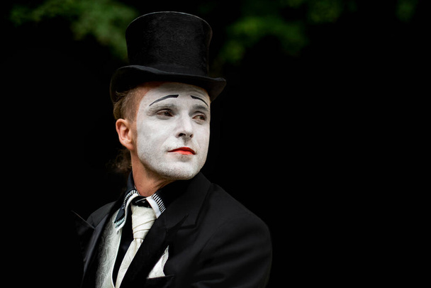 portret van elegante expressieve mannelijke mime kunstenaar poseren op zwarte achtergrond. Close-up portret van een mannelijke mime artiest. Halloween kostuum. - Foto, afbeelding