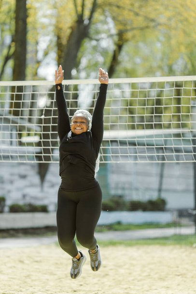 Afro-american plus size woman doing workout exercises session outdoor - Fotó, kép