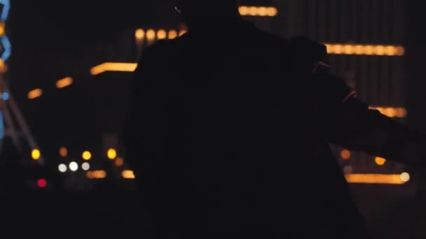 Sorrindo homem segura uma bomba de fumaça iluminada em sua mão à noite - Filmagem, Vídeo