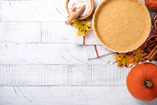 Pumpkin and food ingredients, spices, cinnamon and kitchen utencil on white rustic wooden background. Concept homemade baking for holiday. Cooking pumpkin pie and cookies for Thanksgiving day. - Valokuva, kuva