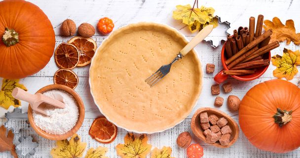 Pumpkin and food ingredients, spices, cinnamon and kitchen utencil on white rustic wooden background. Concept homemade baking for holiday. Cooking pumpkin pie and cookies for Thanksgiving day. - Foto, Bild