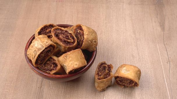 Closeup of plate with sweet pastry rolls on wooden background  - Photo, Image