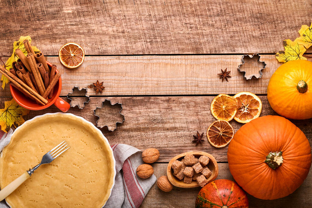 Pumpkin and food ingredients, spices, cinnamon and kitchen utencil on old rustic wooden background. Concept homemade baking for holiday. Cooking pumpkin pie and cookies for Thanksgiving day. - Fotoğraf, Görsel