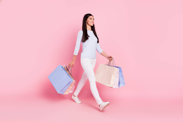 Full length body size view of lovely cheerful girl carrying bags outlet new things isolated over pink pastel color background - Φωτογραφία, εικόνα