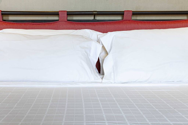 Близько великі білі подушки на білому ліжку
 - Фото, зображення