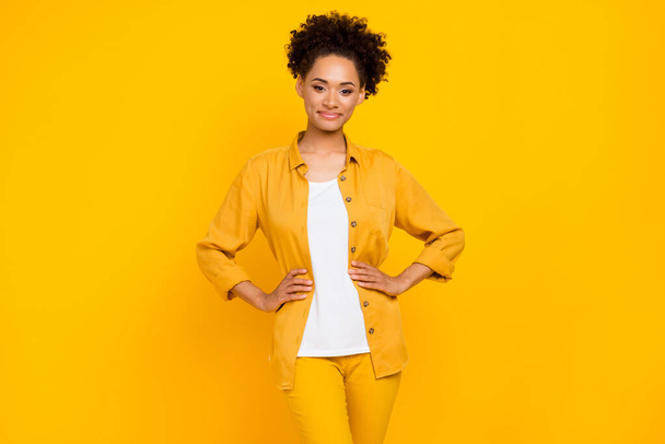Photo of young attractive african woman confident hands on waist smart isolated over yellow color background - Zdjęcie, obraz