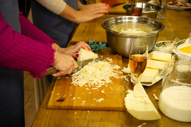 Masterclass over het koken van groentegerechten met kool. Vrouwen bereiden Oekraïense borsjt in de keuken van het restaurant voor op een interessante ontmoeting met vrienden - Foto, afbeelding