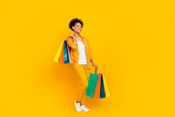 Full body profile side photo of young black girl customer buy shop sale bag isolated over yellow color background - Valokuva, kuva