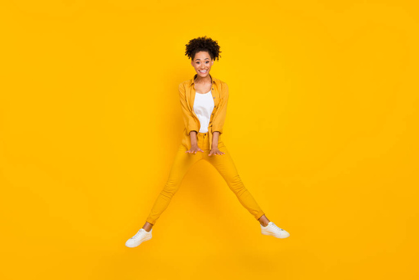 Full length photo of young cheerful black girl have fun jump up fly air isolated over yellow color background - Фото, зображення