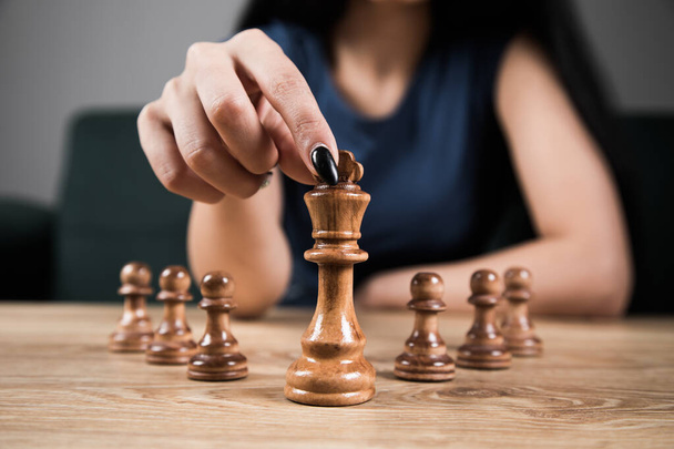 young woman playing chess alone - Fotó, kép