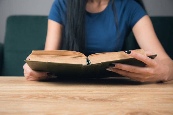 Uma menina lendo um livro na frente de uma mesa - Foto, Imagem