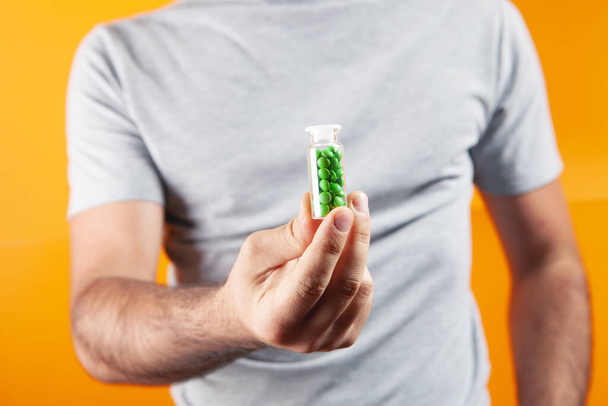 a man puts pills in his hand - Fotó, kép