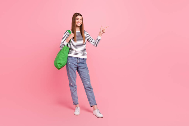 Full length body size view of attractive cheerful girl shopping showing copy space ad isolated over pink pastel color background - Foto, immagini