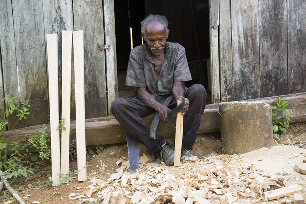 old man sitting and working with wood, travel shot - Photo, Image