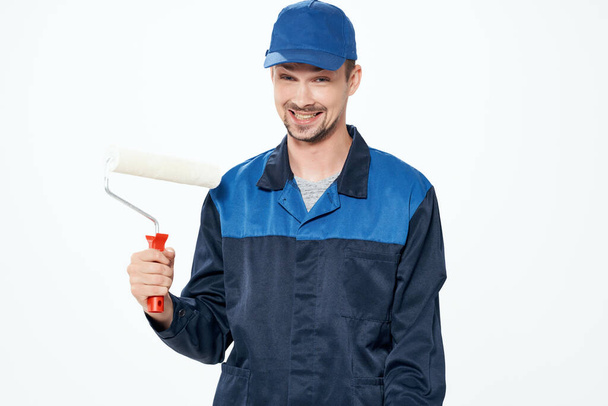 muž v pracovní uniformě malující zdi opravující dům - Fotografie, Obrázek