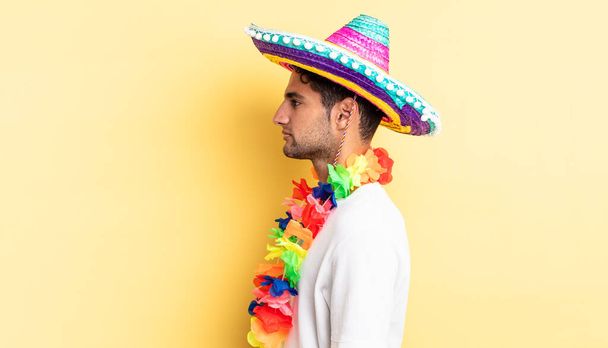 hispanic handsome man on profile view thinking, imagining or daydreaming. mexican party concept - 写真・画像