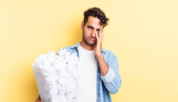 hispanic handsome man feeling bored, frustrated and sleepy after a tiresome. paper balls trash concept - Photo, image