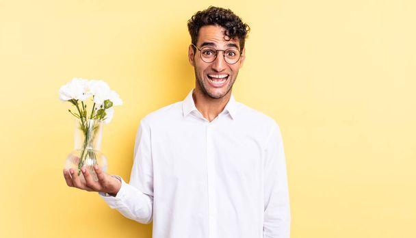 hispanic handsome man looking happy and pleasantly surprised. flowers pot concept - Foto, Imagen