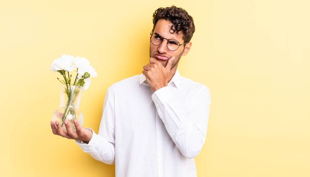 hispanic handsome man thinking, feeling doubtful and confused. flowers pot concept - Foto, Imagen