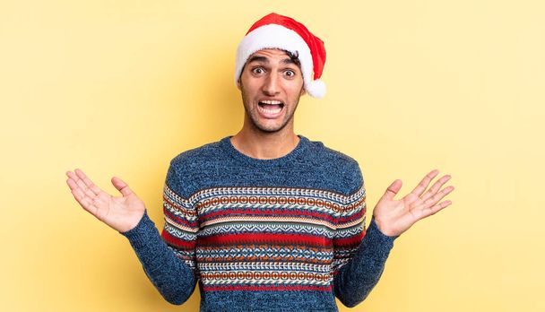hispanic handsome man feeling happy and astonished at something unbelievable. christmas concept - Фото, зображення