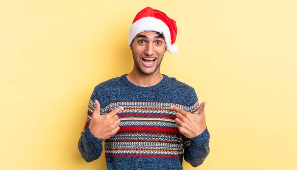hispanic handsome man feeling happy and pointing to self with an excited. christmas concept - Foto, Imagen