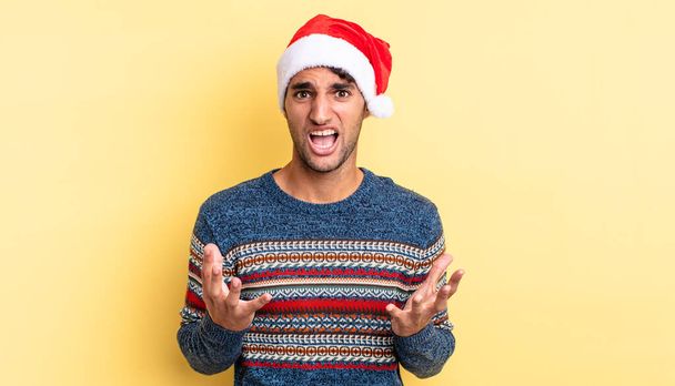 hispanic handsome man looking desperate, frustrated and stressed. christmas concept - Фото, изображение