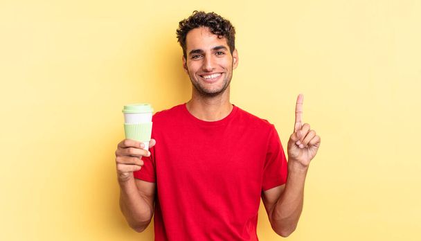 hispanic handsome man smiling and looking friendly, showing number one. take away coffee concept - Valokuva, kuva