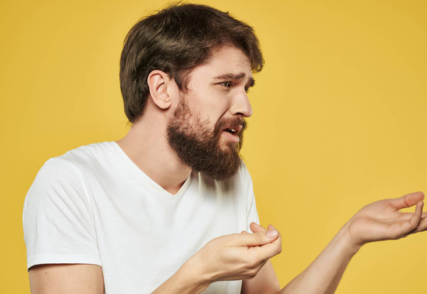 bearded man in white t-shirt yellow background studio emotion problems - Фото, изображение