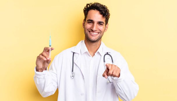 hispanic handsome man pointing at camera choosing you physician and srynge concept - Фото, зображення