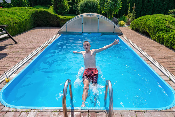 Yüzme havuzuna atlayan engelli adam - Fotoğraf, Görsel