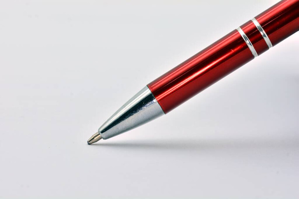 στενή άποψη ενός μεταλλικού στυλό σε ένα λευκό έγγραφο χαρτί - Φωτογραφία, εικόνα