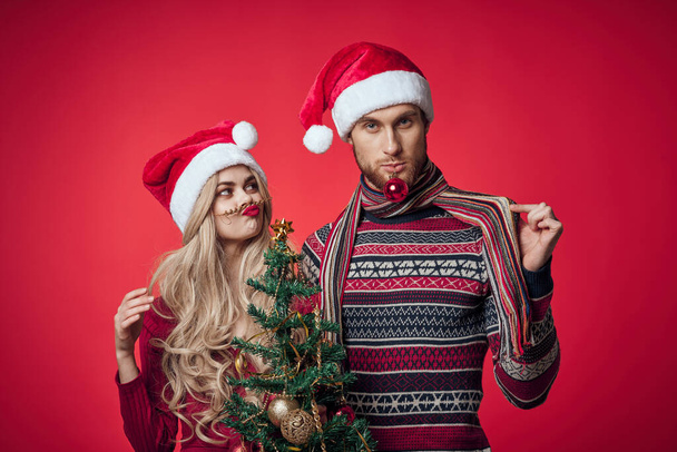 man and woman new year celebration together christmas red background - Fotó, kép