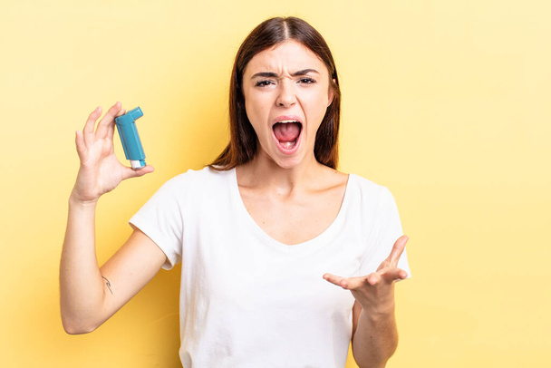 young hispanic woman looking angry, annoyed and frustrated. asthma concept - 写真・画像