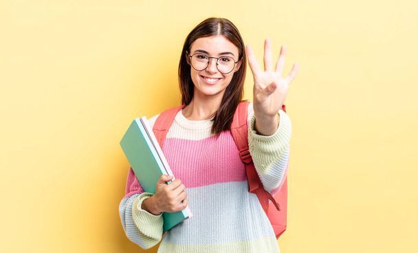 young hispanic woman smiling and looking friendly, showing number four. student concept - Fotoğraf, Görsel